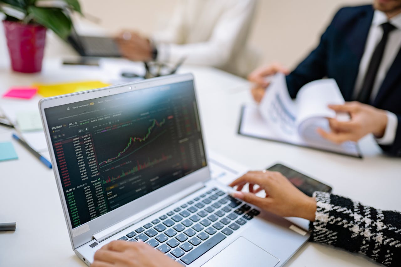 gallery-4 Business team analyzes cryptocurrency market trends using a laptop with graphs and data.